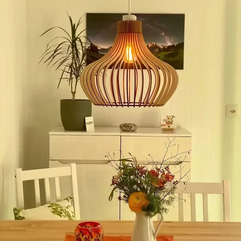 Holzlampe Baidur leuchtet über einem Esstisch